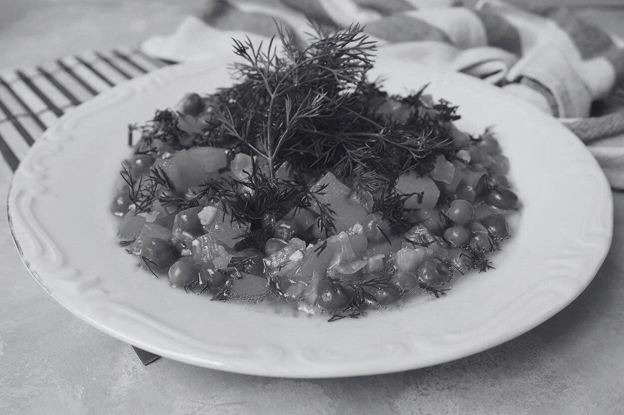 A serving of peas with olive oil in a dish, emphasizing the rich colors and healthy Mediterranean ingredients.